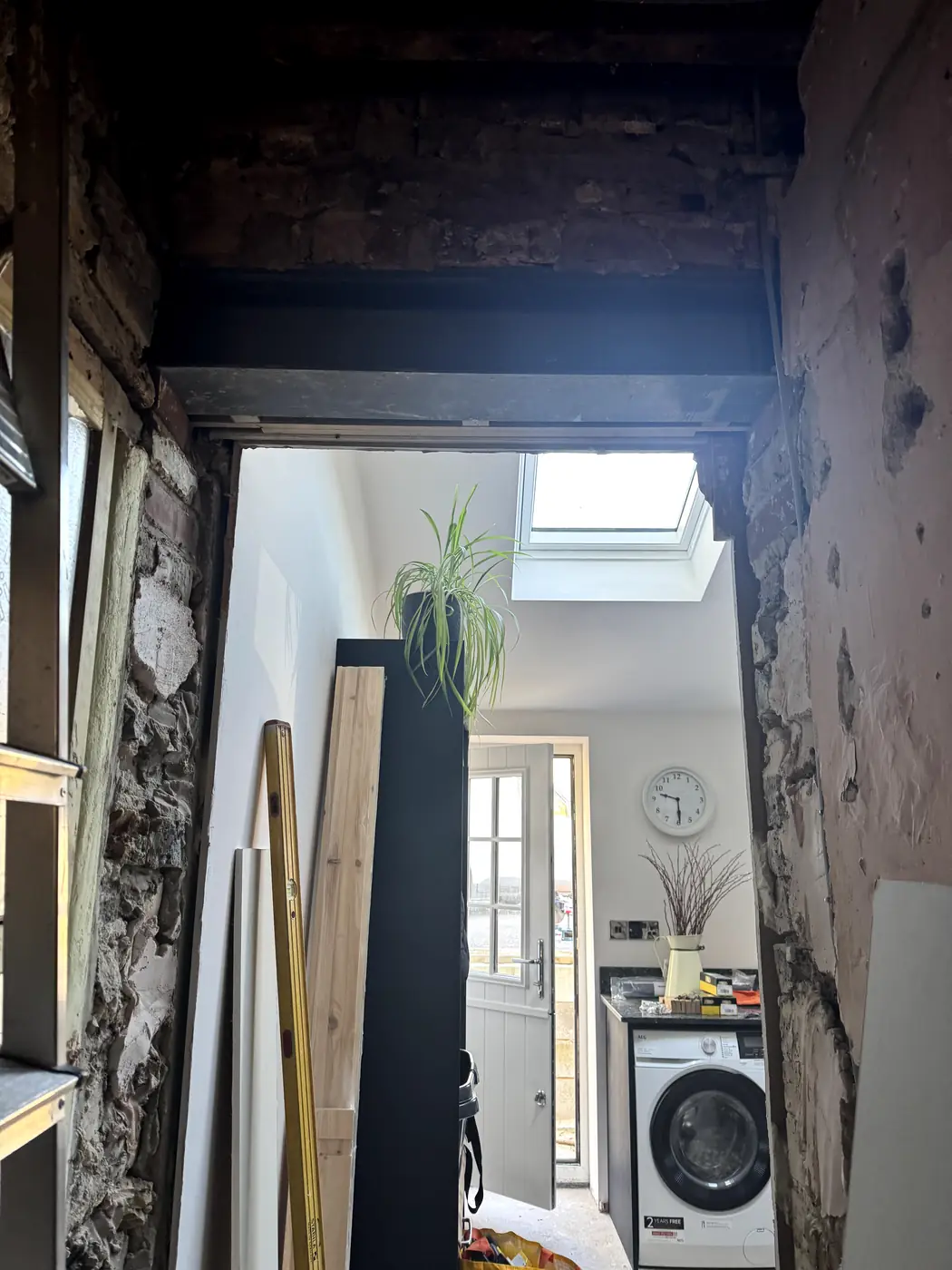 View through completed doorway into a utility room with skylight